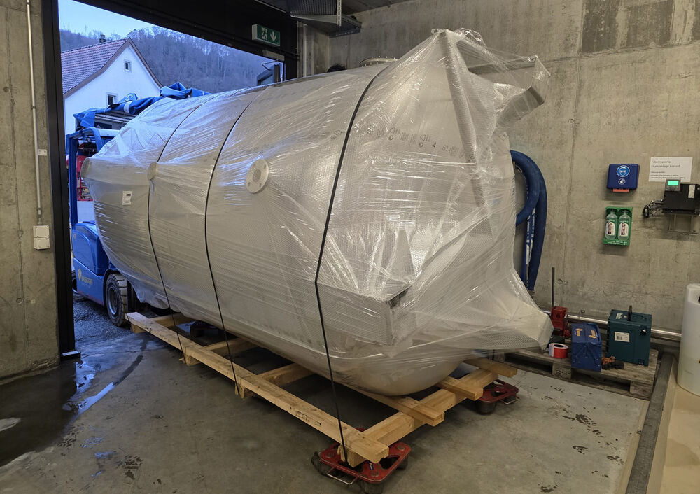 Mineralquelle Lostorf: Der Behälter wird liegend auf Transportrollen ins Gebäude eingebracht.